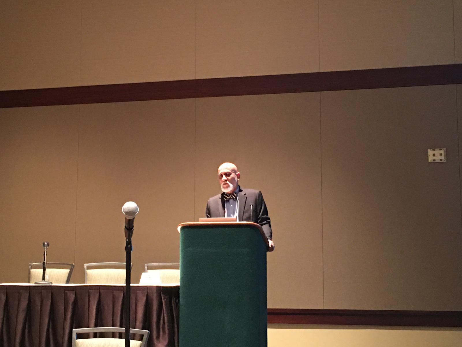 Dr. Frederick Tyson delivering a plenary talk in a conference ballroom