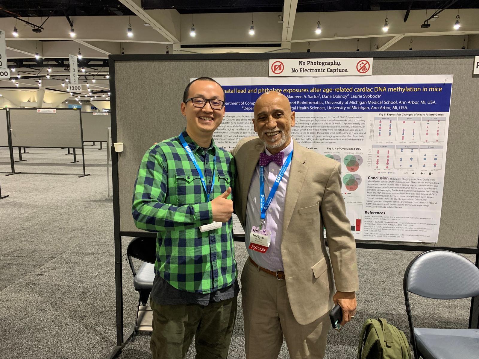 Dr. Frederick Tyson with a researcher at a conference poster session