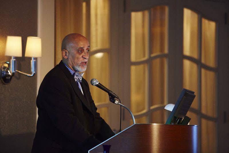 Dr. Frederick Tyson addressing an audience from a lectern