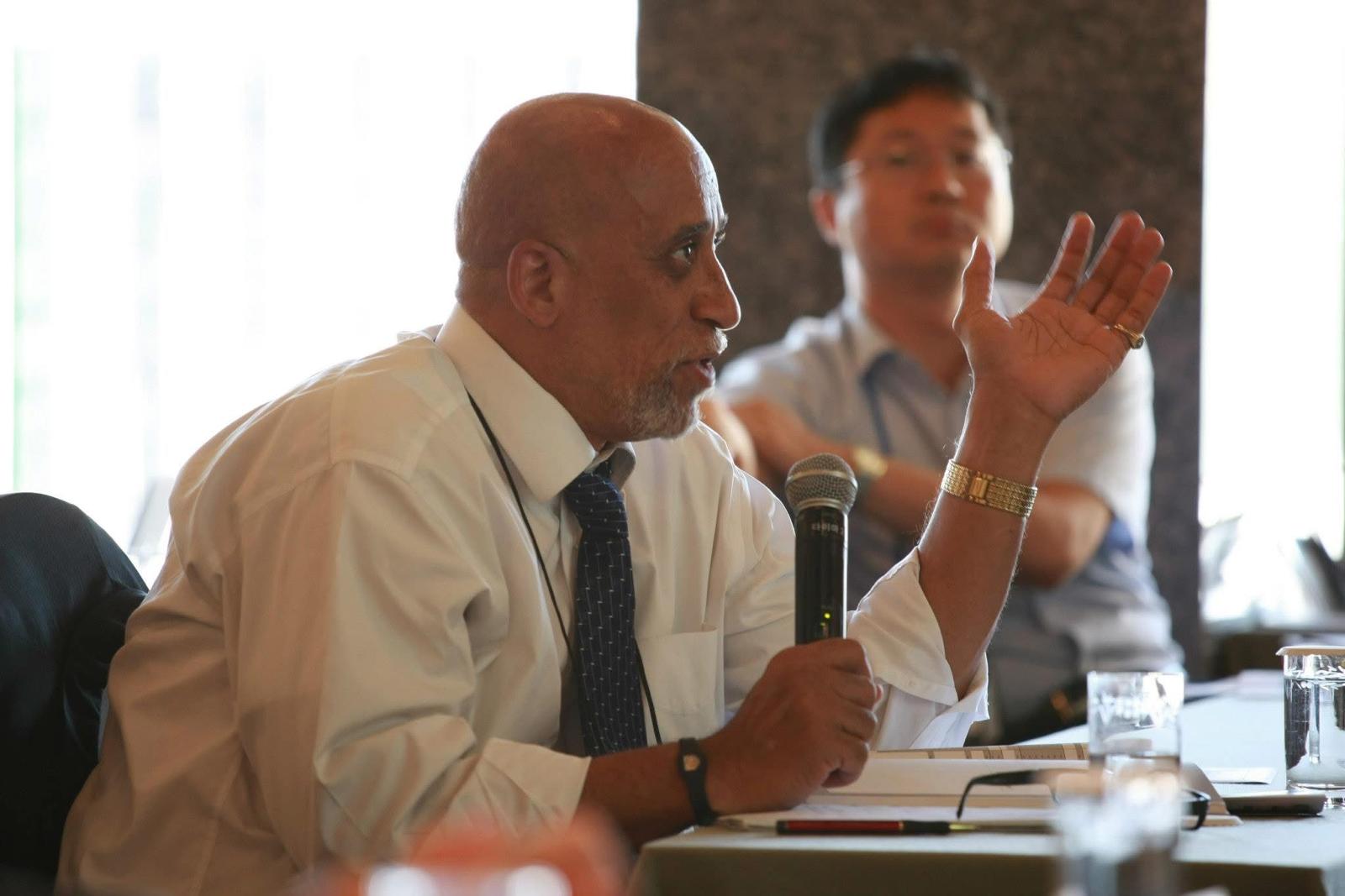 Dr. Frederick Tyson making a point with a microphone during a roundtable discussion