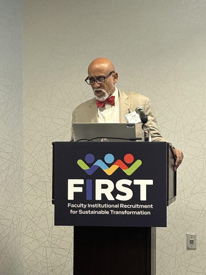 Dr. Frederick Tyson presenting at a FIRST program podium