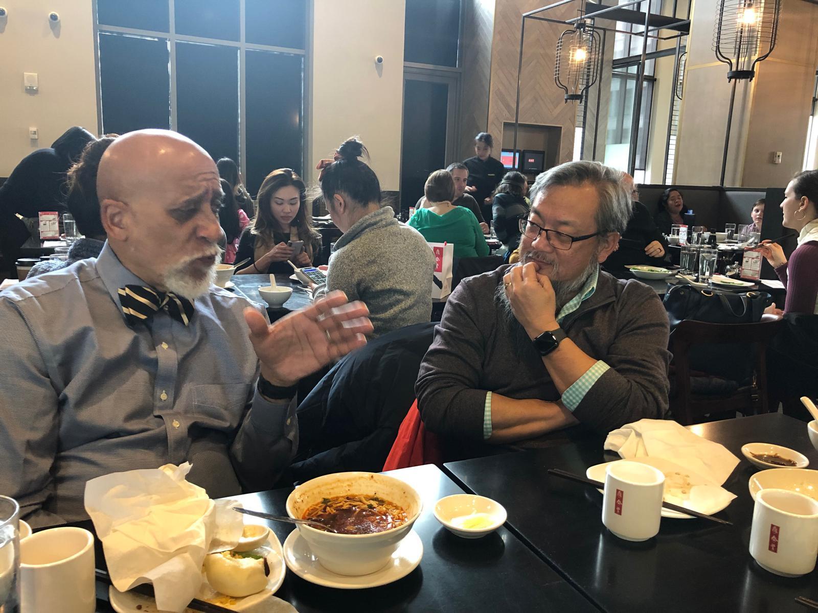 Dr. Frederick Tyson in conversation with a colleague over a meal
